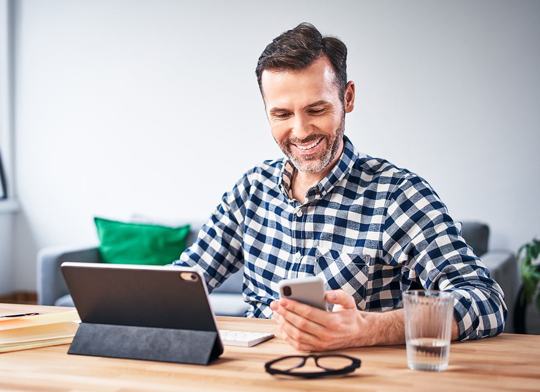 Blog - Man Checking His Smartphone While Working From Home