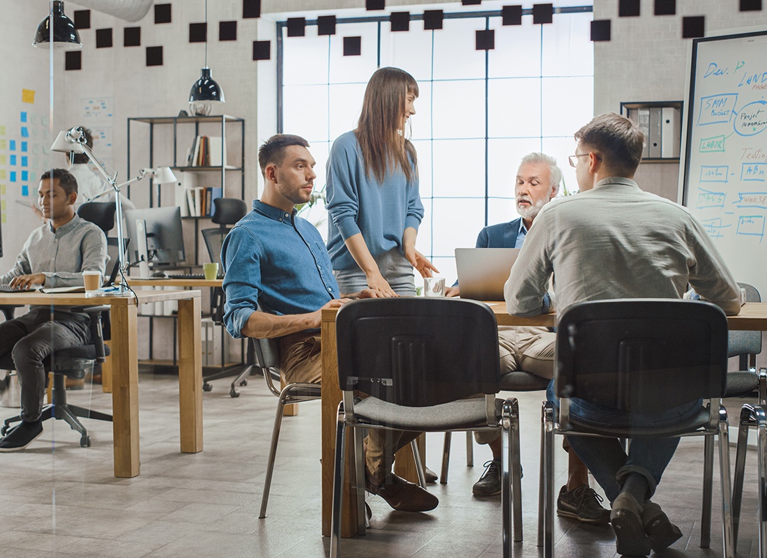 Grey Eagle, MN - Group of Professionals Sitting Down Together in an Industrial Style Office