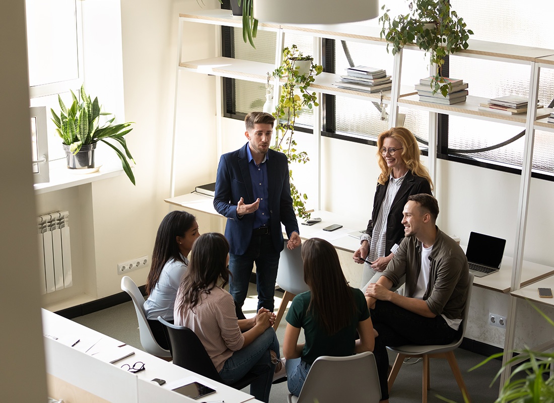 Hudson, WI - Group of Professionals Sitting Together in a Meeting Room With Plants