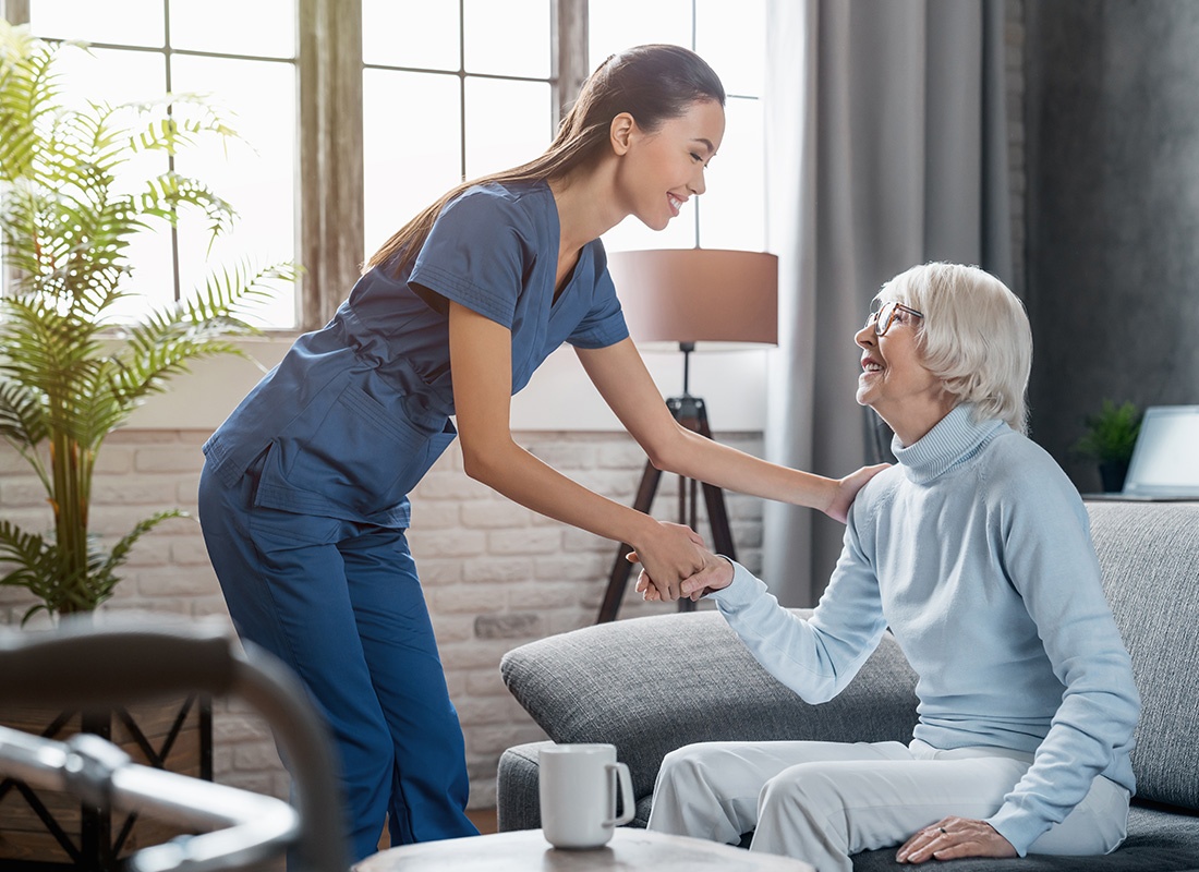 Insurance by Industry - Happy Female Professional Caregiver Taking Care of Elderly Woman at Home